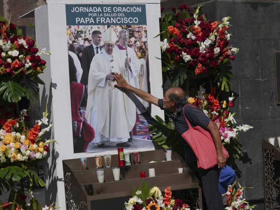 Farník sa dotýka obrazu pápeža Františka počas modlitby v Mexico City.