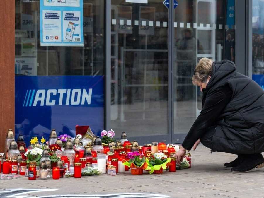 Na snímke sviečky pred obchodom, v ktorom došlo k útoku.