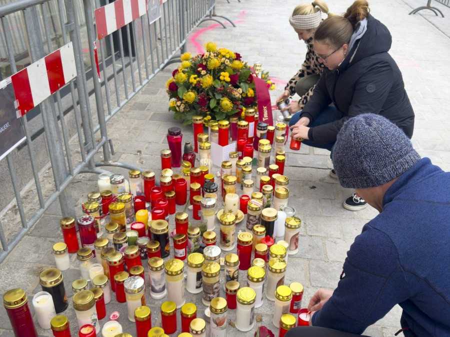 Ľudia zapaľujú sviečky na mieste útoku v rakúskom Villachu.