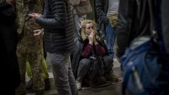 Na archívnej snímke žena čaká na vlak, ktorý sa snaží odísť z Kyjeva na Ukrajine.