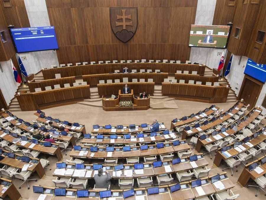 Poslanci sedia v rokovacej sále parlamentu.