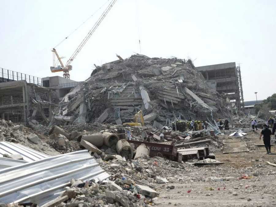 Záchranári pracujú na mieste rozostavanej výškovej budovy, ktorá sa zrútila po zemetrasení.