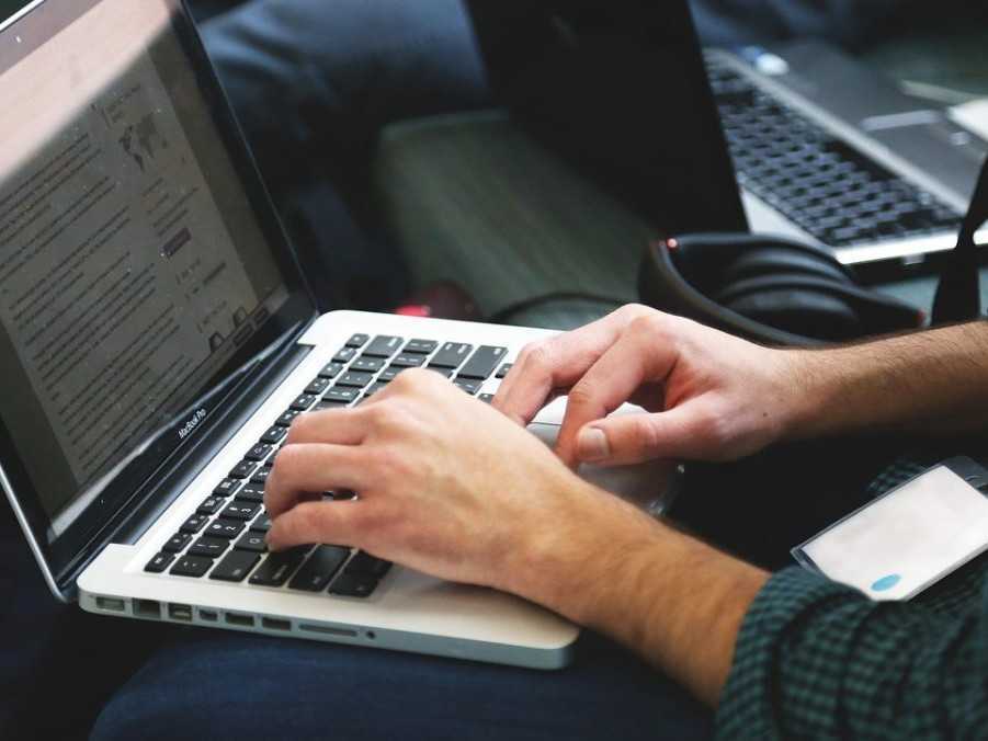 Osoba píše na laptope.