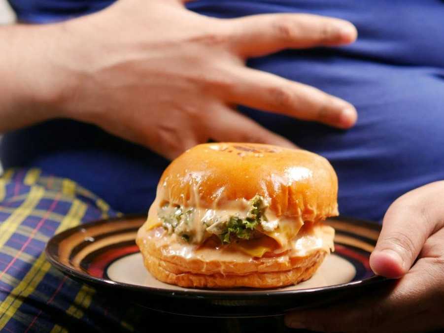 Na snímku muž s burgrom na tanieri.