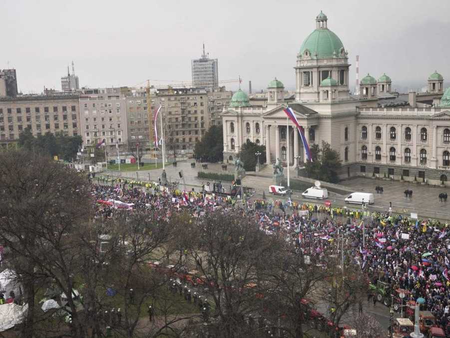 Na snímke demonštranti pochodujú okolo budovy srbského parlamentu 15. 3. 2025.