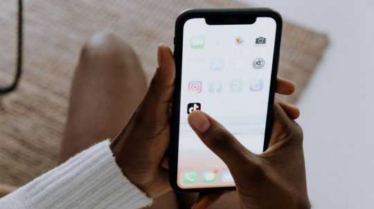 Na ilustračnej snímke žena na telefóne zapína aplikáciu TikTok.