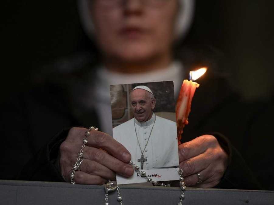 Mníška drží sviečku a fotografiu pápeža Františka.