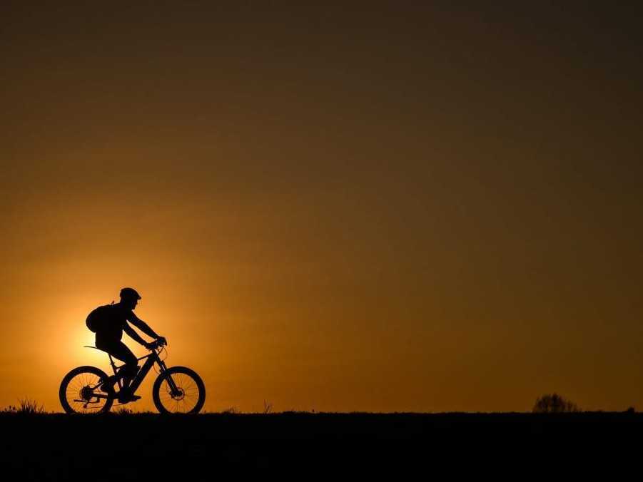 Cyklista na bratislavskej hrádzi pri západe slnka.