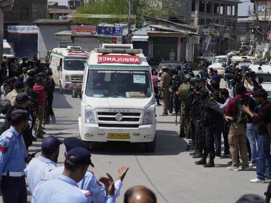 Policajti sprevádzajú sanitky, ktoré privážajú telá zabitých turistov.