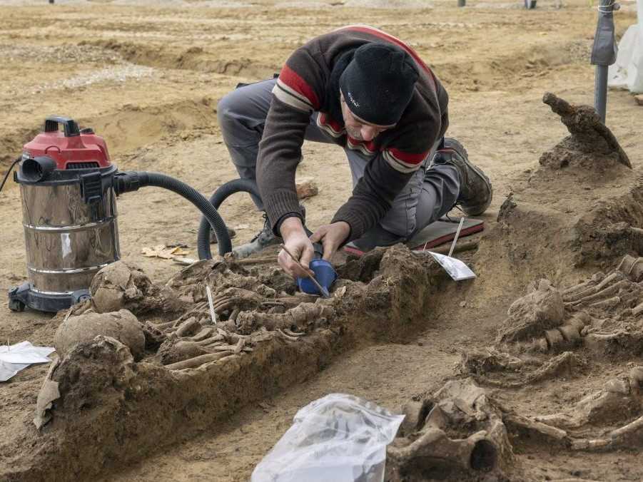 Na archívnej snímke archeológ analyzuje masový hrob s ostatkami vojakov zo starorímskych čias vo Viedni.