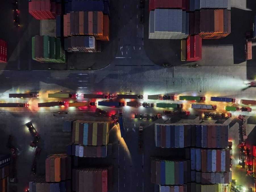 Kamióny čakajú na odchod z kontajnerového terminálu v Číne.