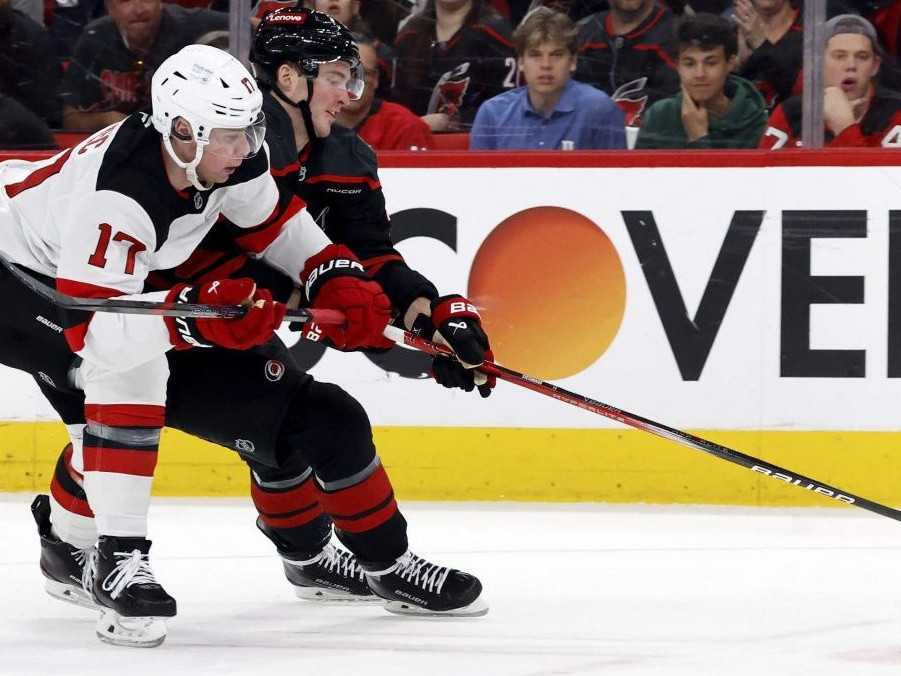 Slovenský hráč New Jersey Devils Šimon Nemec (vľavo) bojuje o puk s Andreiom Svechnikovom z Caroliny Hurricanes.