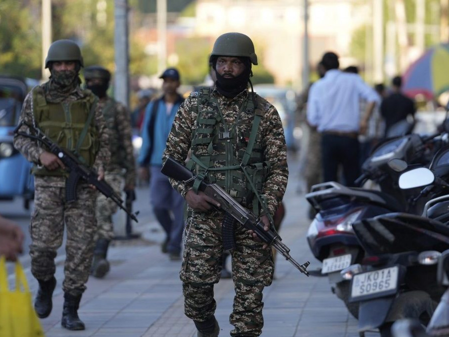 Na snímke príslušníci indických polovojenských síl hliadkujú na rušnom trhovisku v indickej časti Kašmíru.