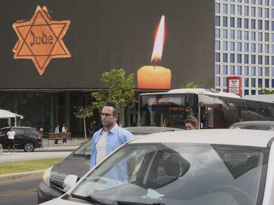 Ľudia stoja pri svojich autách počas sirény na pamiatku obetí holokaustu v Tel Avive.