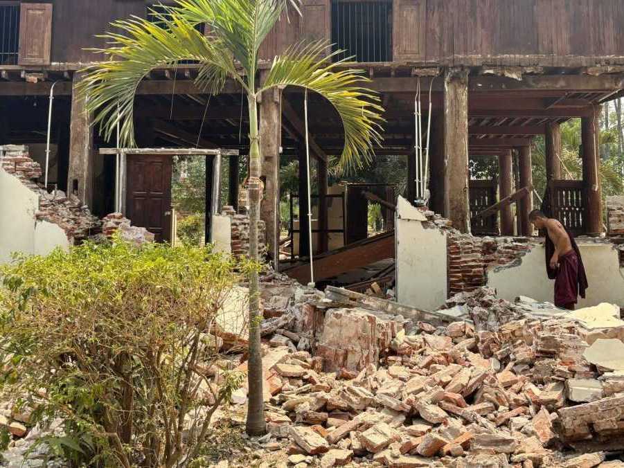 Budhistický mních kráča okolo poškodenej budovy v kláštornom komplexe po zemetrasení v mjanmarskej metropole Nepjito.