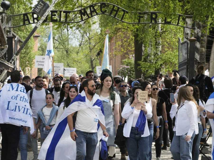 Ľudia na Pochode živých pred bývalým nacistickým koncentračným táborom Auschwitz.