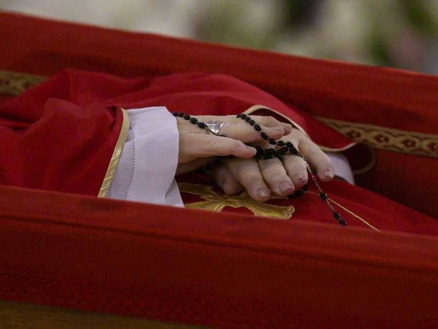 Zosnulý pápež František s ružencom v založených dlaniach.