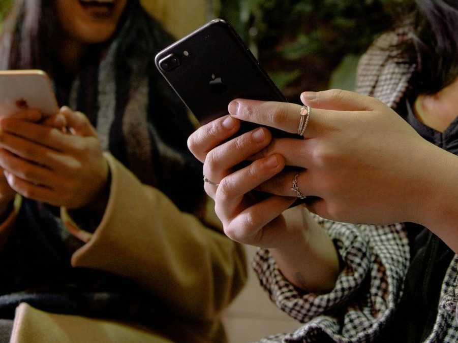 Na ilustračnej snímke dve ženy držia telefóny.