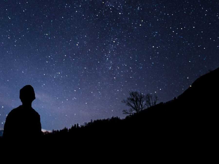 Ilustračná snímka muža pozorujúceho nočnú oblohu.