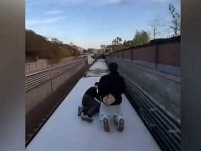 Na snímke mladíci na streche metra.