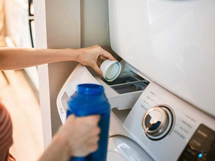 Na ilustračnej snímke žena vlieva prací gél do práčky.