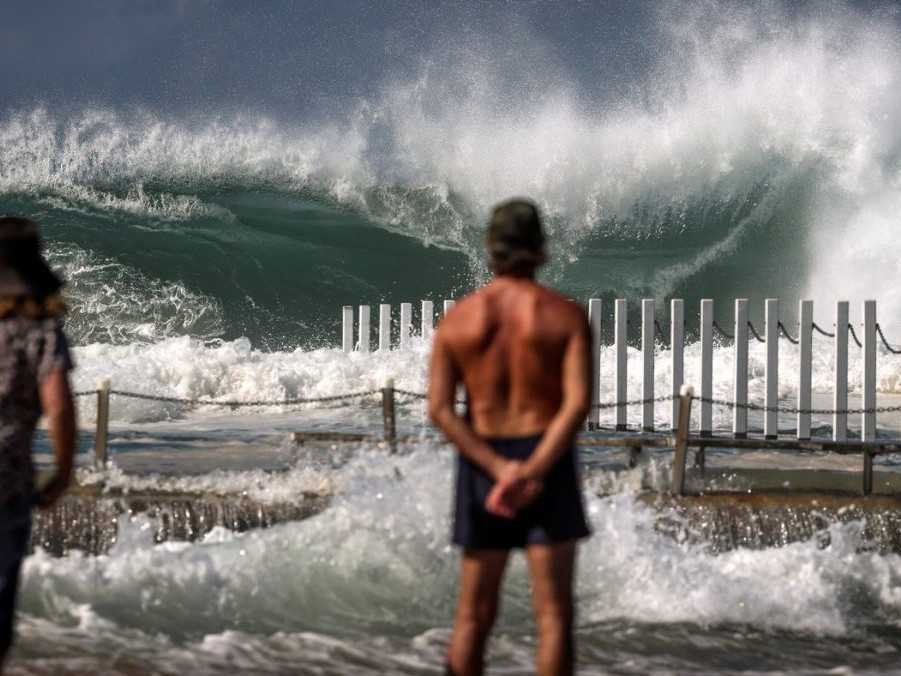 Na snímke ľudia pozorujú vlny na austrálskom pobreží.