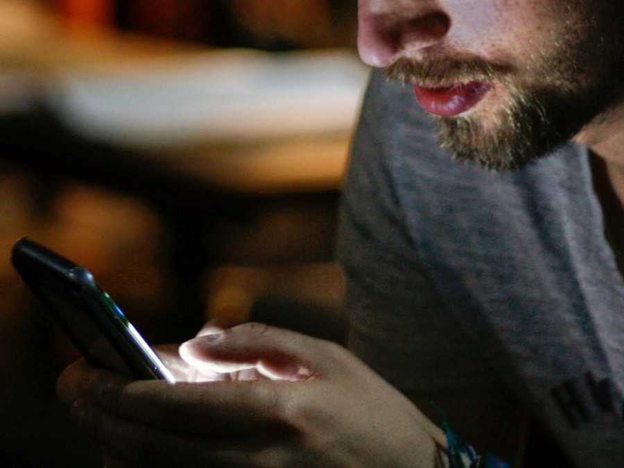 Na snímke muž, ktorý používa mobilný telefón.