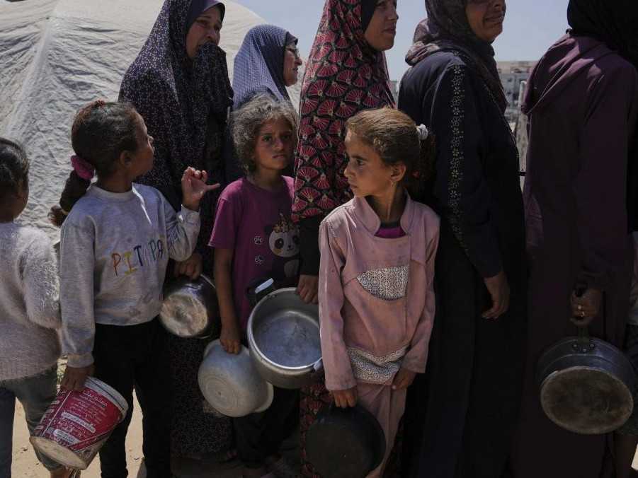 Vysídlení Palestínčania stoja v rade v komunitnej kuchyni.