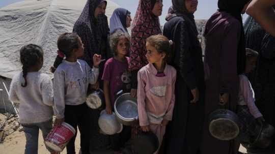 Vysídlení Palestínčania stoja v rade v komunitnej kuchyni.