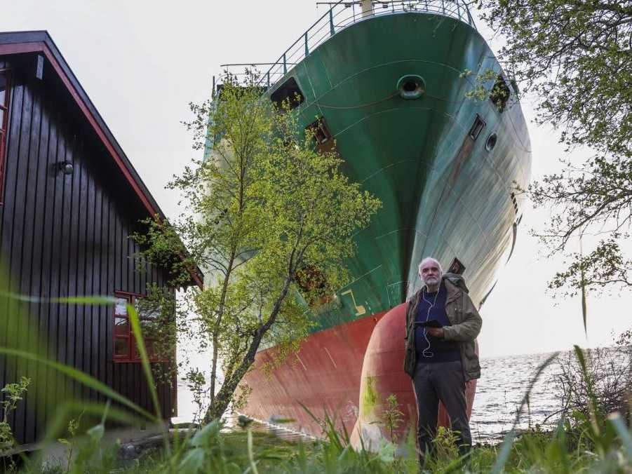 V popredí Johan Helberg, za ním kontajnerová loď.