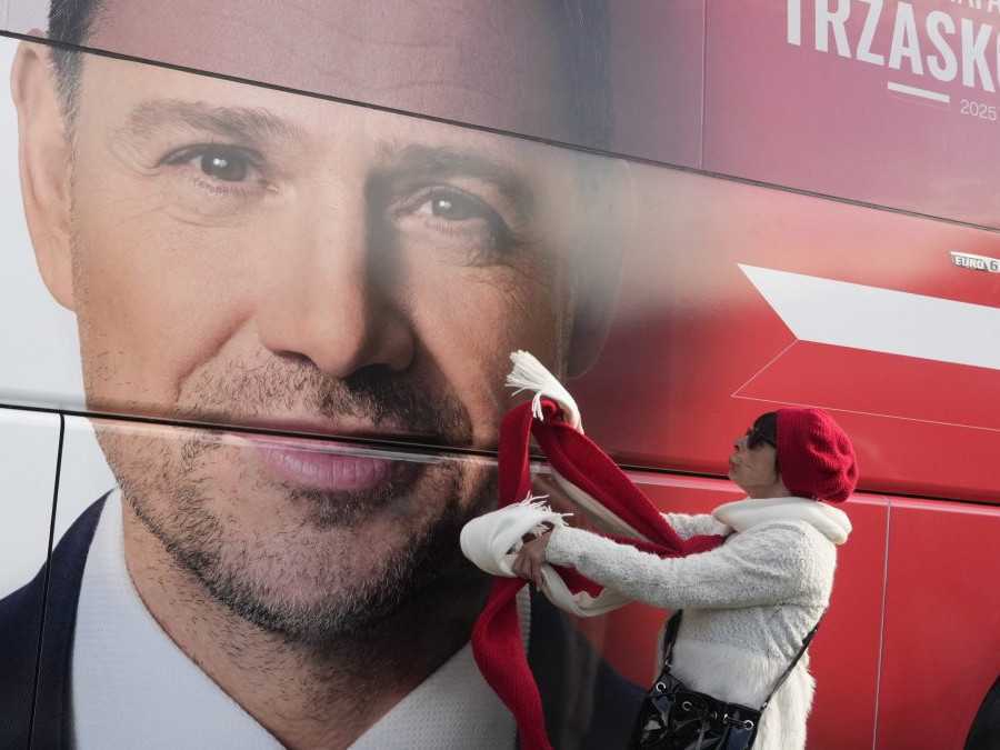 Žena pri plagáte prezidentského kandidáta a starostu Varšavy Rafal Trzaskowski.