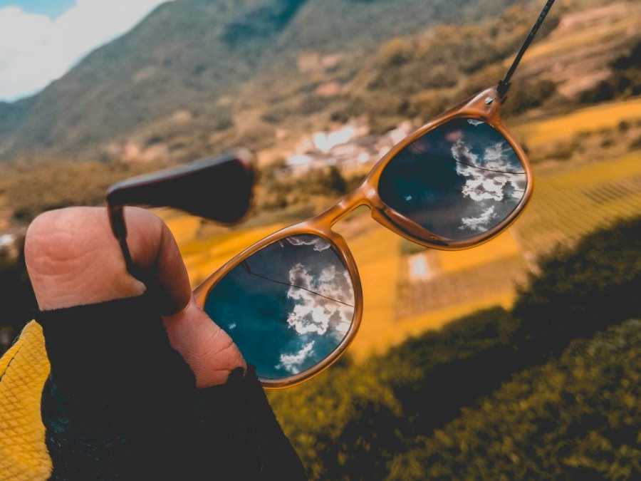 Osoba na snímke drží v rukách slnečné okuliare.