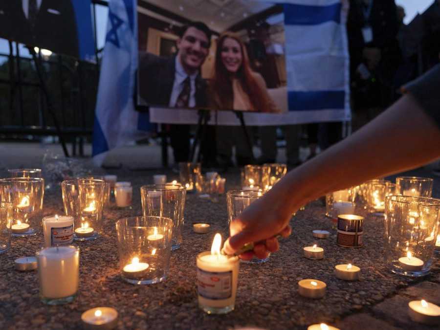 Na snímke osoba zapaľuje sviečku na pietnom mieste pre zavraždený pár z izraelskej ambasády vo Washingtone.