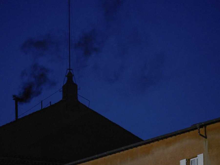 na snímke komín vo Vatikáne, z ktorého prúdi čierny dym.