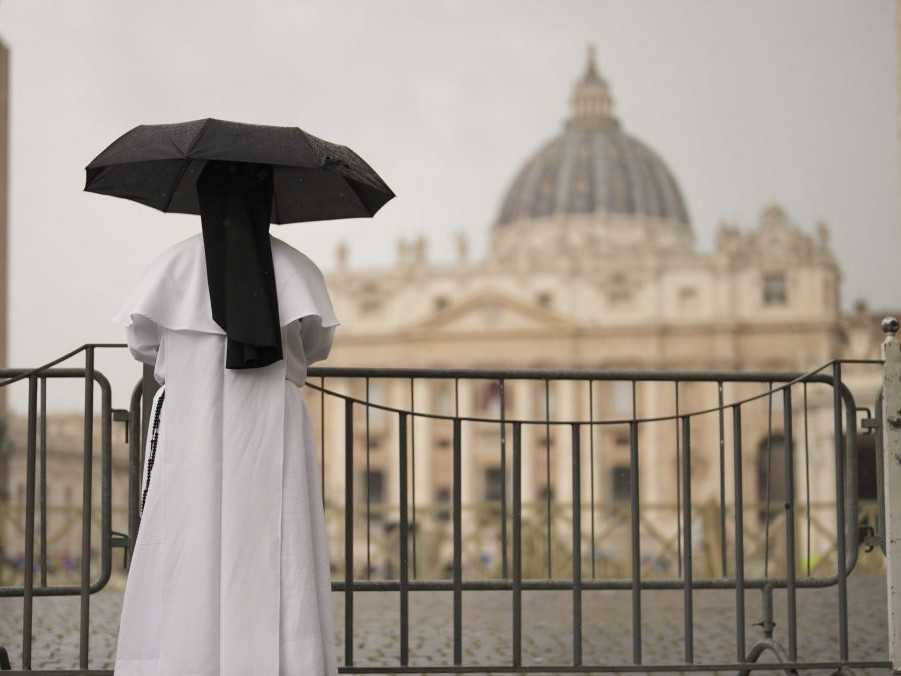 mníška s dáždnikom stojí pred Bazilikou sv. Petra