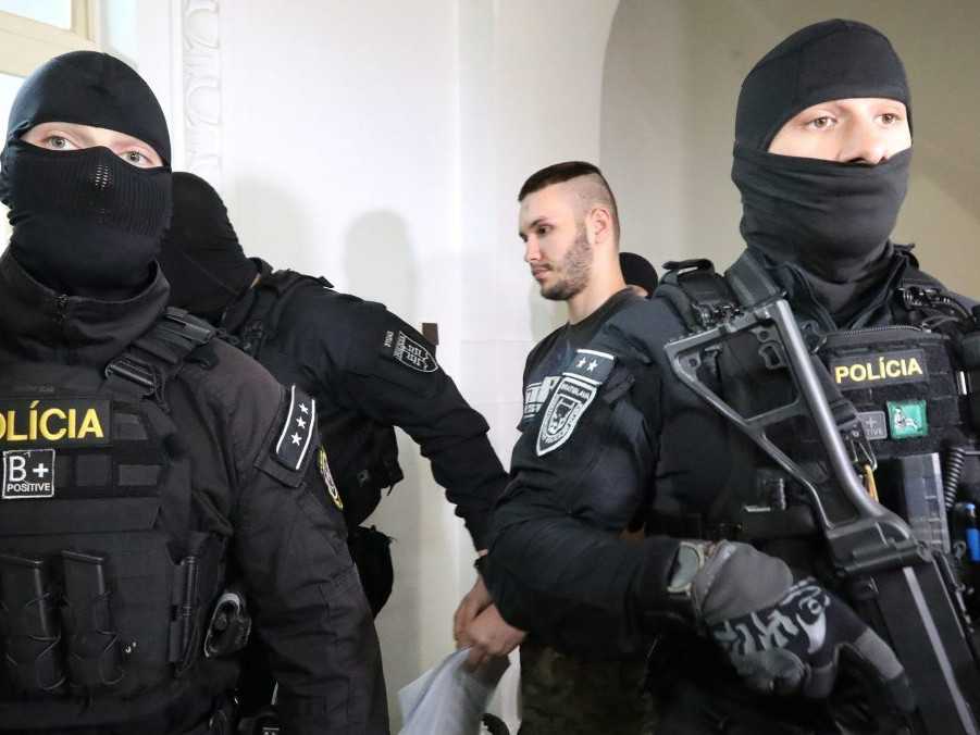 obvinený v sprievode policajnej eskorty