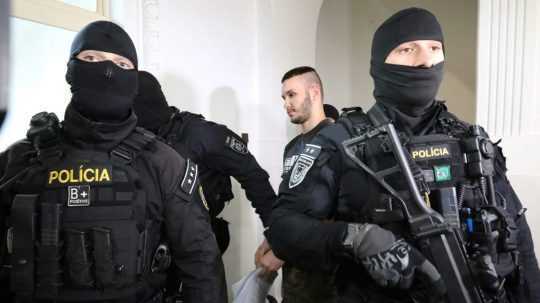 obvinený v sprievode policajnej eskorty