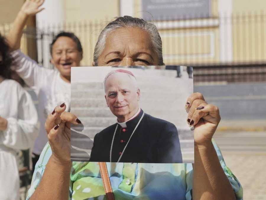 Veriaca žena drží fotografiu Roberta Prevosta, ktorý bol zvolený za pápeža Leva XIV., pred katedrálou v Chiclayo v Peru.