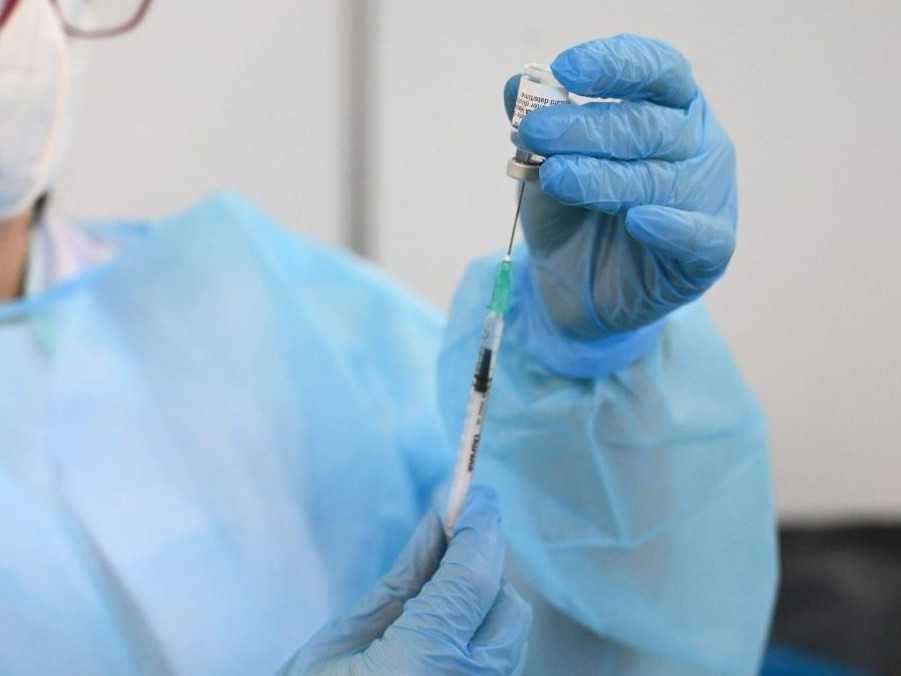 Na ilustračnej snímke zdravotná sestra s vakcínou v ruke.