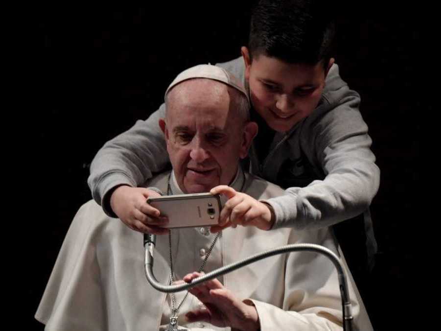 Na archívnej snímke chlapec si fotí selfie s pápežom Františkom.