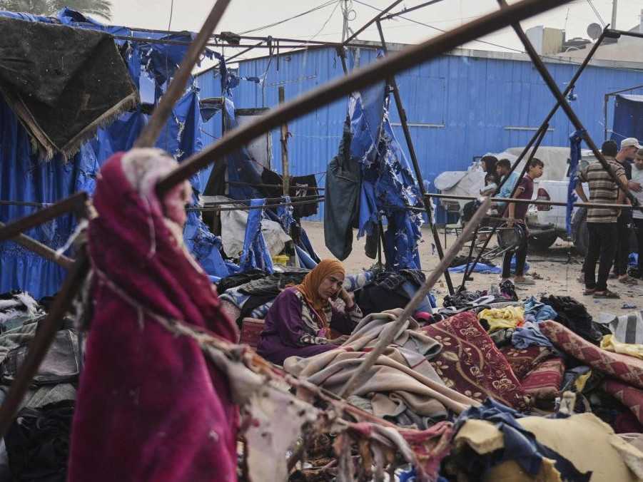 Na snímke Palestínčania si prezerajú škody spôsobené izraelským náletom.