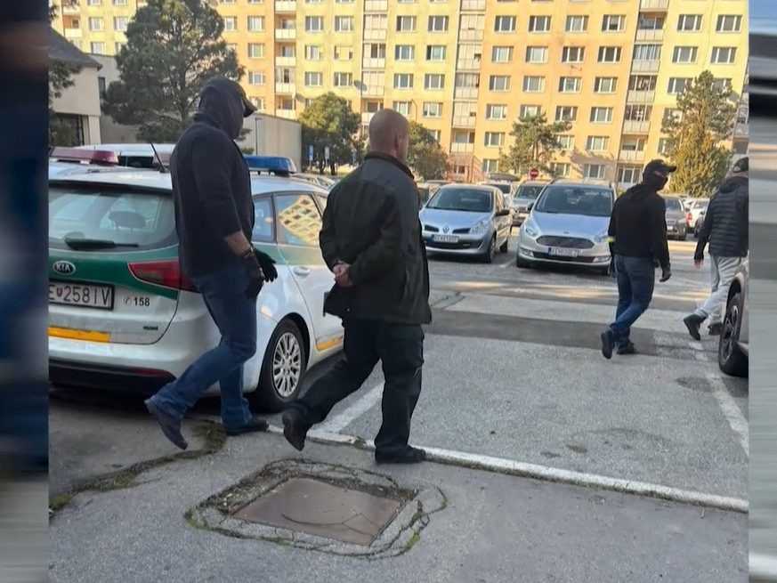 Na archívnej snímke polícia odvádza jedného z obžalovaných expolicajtov.