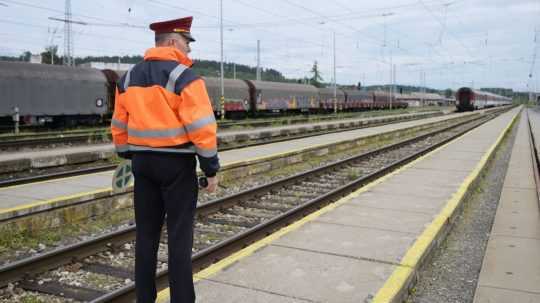 Výpravca sleduje vracajúci sa vlak.