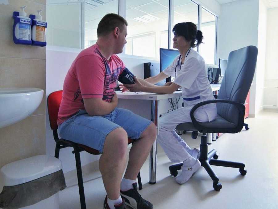 Na ilustračnej snímke zdravotná sestra meria tlak pacientovi.