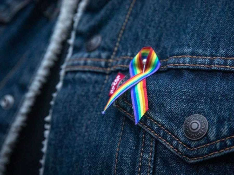 Na snímka denimová bunda s pripnutou dúhovou stužkou.