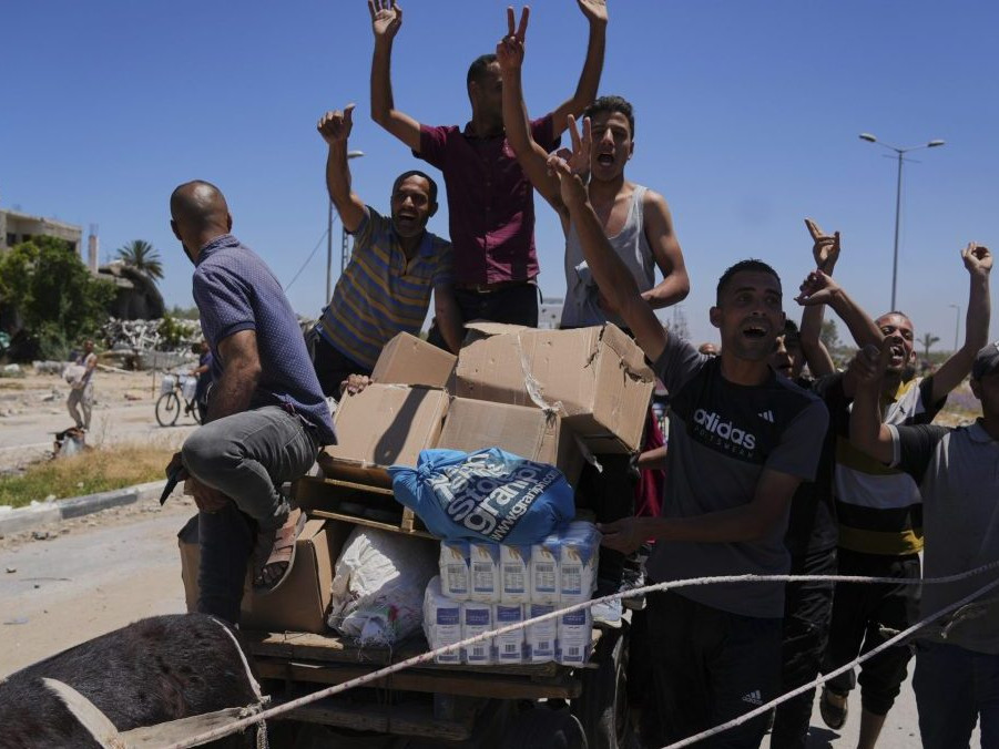 Palestínčania nesú krabice s jedlom a balíčky s humanitárnou pomocou.