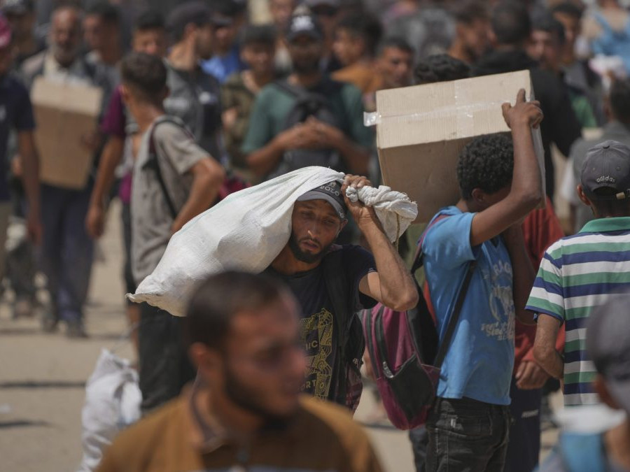 Palestínčania nosia krabice a tašky s potravinami a balíčkami humanitárnej pomoci.