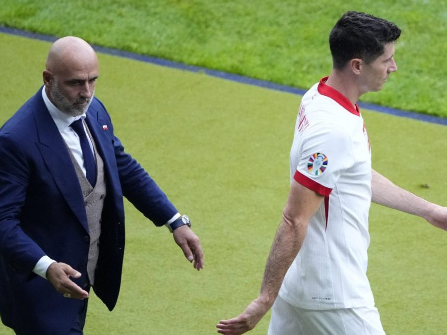 Poľský futbalista Robert Lewandowski kráča vedľa trénera Poľska Michala Probierza.