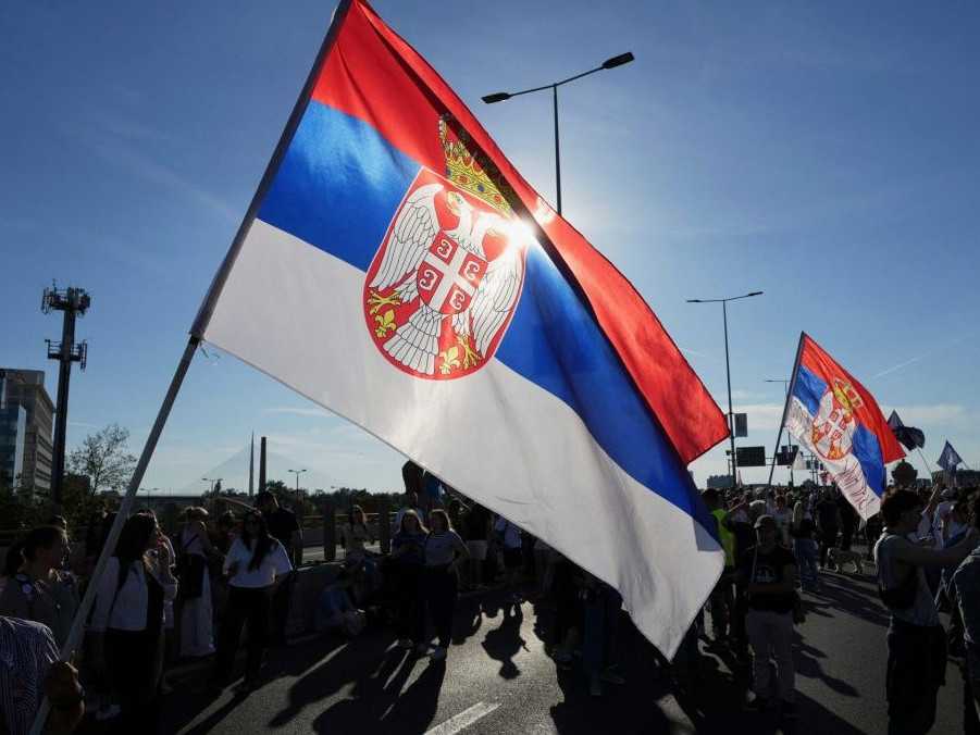 Protestujúci so srbskou vlajkou.