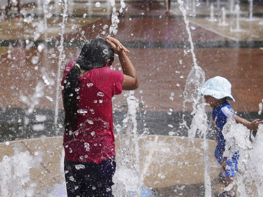 Na snímke sa deti hrajú vo fontáne počas vysokých teplôt.